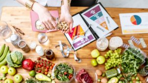 Dietitian holding nuts above the table full of healthy food