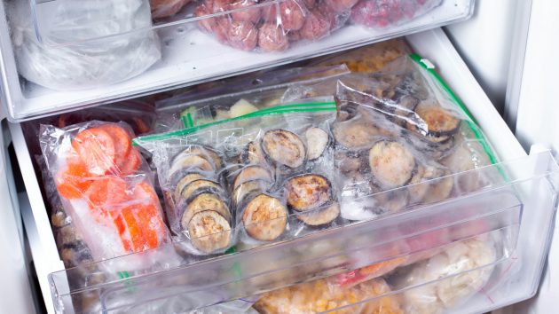 erriesPlastic bags with different frozen vegetables in refrigerator